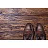 Classic male brown leather shoes on wooden background