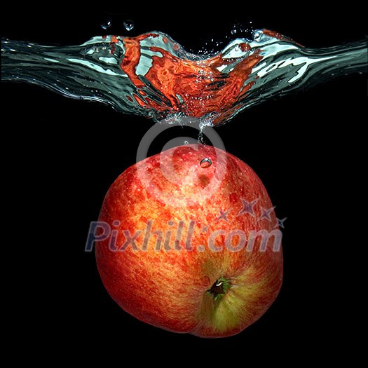 green apple dropped into water with splash isolated on black green apple dropped into water with splash isolated on black