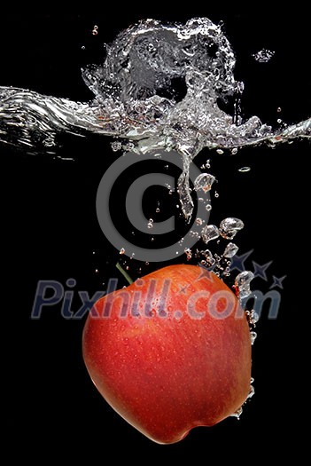 green apple dropped into water with splash isolated on black green apple dropped into water with splash isolated on black