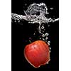 green apple dropped into water with splash isolated on black
