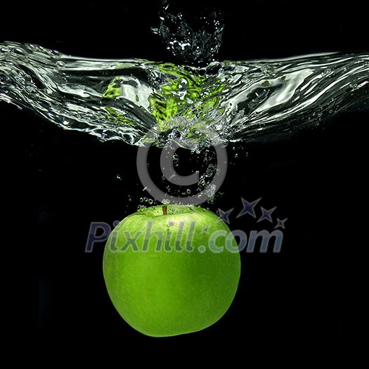 green apple dropped into water with splash isolated on black green apple dropped into water with splash isolated on black