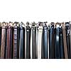 a lot of leather belts in store isolated on white