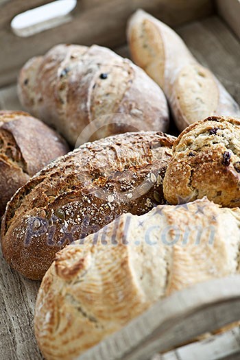 Various kinds of fresh baked bread loaves in wooden tray Various kinds of fresh baked bread loaves in wooden tray
