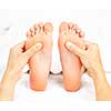Female hands giving massage to soft bare feet