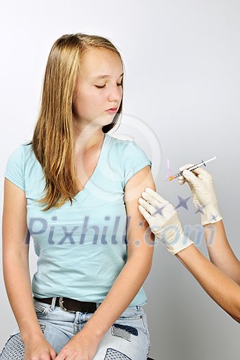 Teenage girl getting flu shot needle vaccination in arm Teenage girl getting flu shot needle vaccination in arm