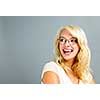 Happy young woman wearing eyeglasses looking to the side on grey background