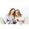 Two smiling women using mobile devices with colorful cases