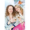 Two happy women celebrating with glasses of white wine