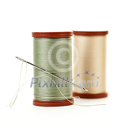 Two spools of thread with needle for sewing isolated on white background Two spools of thread with needle for sewing isolated on white background