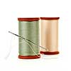 Two spools of thread with needle for sewing isolated on white background