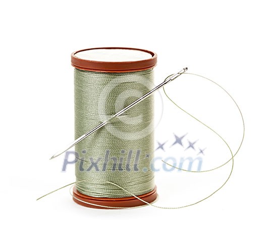 Spool of thread with needle for sewing on white background Spool of thread with needle for sewing on white background