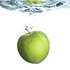 green apple dropped into water with bubbles isolated on white