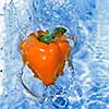 Yellow pepper dropped into water with bubbles
