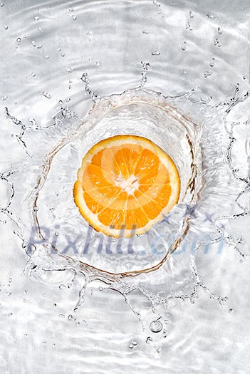 Fresh orange dropped into water with bubbles isolated on white Fresh orange dropped into water with bubbles isolated on white