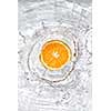 Fresh orange dropped into water with bubbles isolated on white