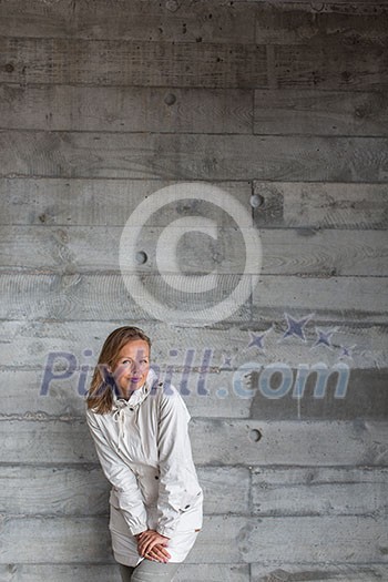 Pretty, young woman in front of a concrete wall (copy space available; color toned image) Pretty, young woman in front of a concrete wall (copy space available; color toned image)