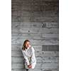 Pretty, young woman in front of a concrete wall (copy space available; color toned image)
