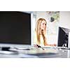 Pretty, female student looking at a desktop computer screen, learning unpleasant news about her exam results. University/office/school concept