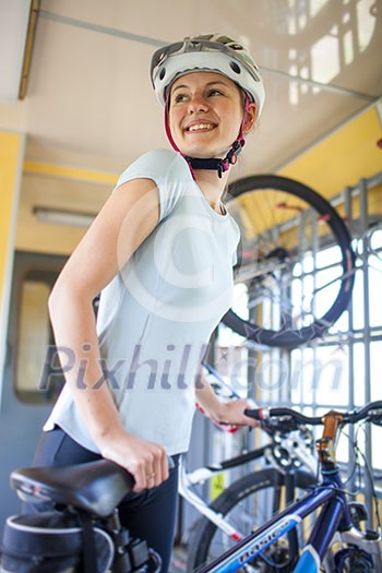 Cycling tourism: young woman traveling by train with her bike Cycling tourism: young woman traveling by train with her bike