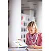 in the library - pretty female student with books working in a high school library (color toned image)