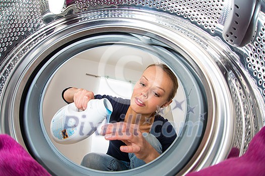 Housework: young woman doing laundry (shallow DOF; color toned image) Housework: young woman doing laundry (shallow DOF; color toned image)