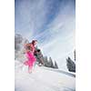 Young woman snowshoeing in high mountains, enjoying a lovely day