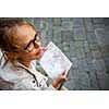 Gorgeous female tourist with a map discovering a foreign city (shallow DOF; color toned image)