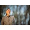 Portrait of a senior man outdoors, walking in a park (shallow DOF; color toned image)