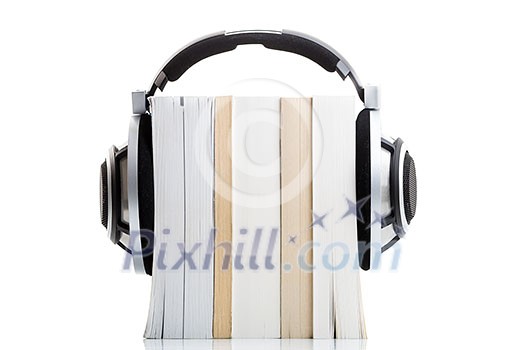 Audiobook concept - listen to your books in HD quality; hi-end hifi headphones over multiple books on white Audiobook concept - listen to your books in HD quality; hi-end hifi headphones over multiple books on white