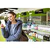 Young woman looking for the right pills in a modern pharmacy (shallow DOF; color toned image)