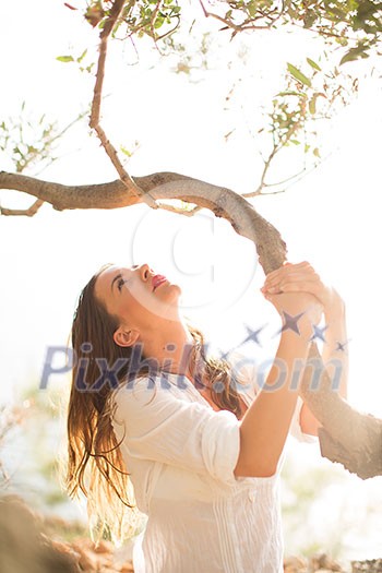 Attractive, young brunette on the beach, amid olive trees, looking both sensual and natural Attractive, young brunette on the beach, amid olive trees, looking both sensual and natural