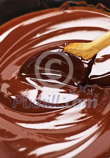 Wooden spoon stirring soft melted rich chocolate Wooden spoon stirring soft melted rich chocolate