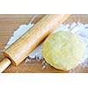 Wooden rolling pin and ball of cookie dough with flour
