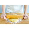 Spreading out cookie dough with wooden rolling pin