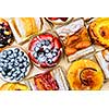 Background of assorted fresh sweet tarts and pastries from above