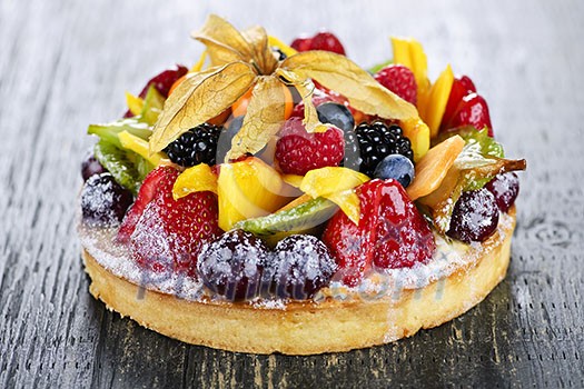 Fresh dessert fruit tart covered in assorted tropical fruits Fresh dessert fruit tart covered in assorted tropical fruits