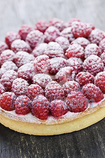Fresh dessert fruit tart covered in raspberries Fresh dessert fruit tart covered in raspberries