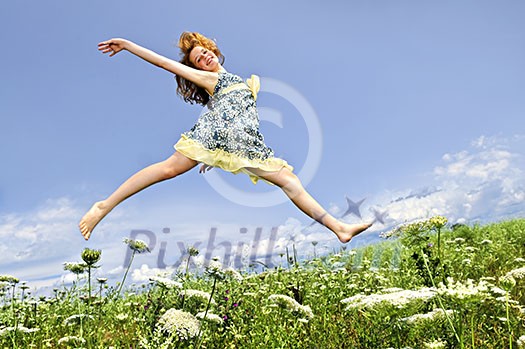 Young teenage girl jumping in summer meadow amid wildflowers Young teenage girl jumping in summer meadow amid wildflowers