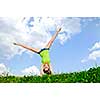 Young teenage girl doing cartwheel in a summer meadow
