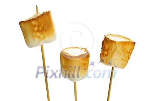Three golden toasted marshmallows on wooden skewers Three golden toasted marshmallows on wooden skewers