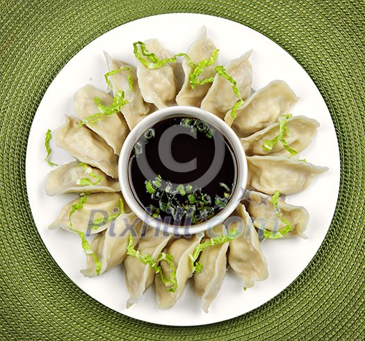 Plate of steamed dumplings with soy sauce from above Plate of steamed dumplings with soy sauce from above