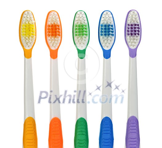 Close up of multicolored toothbrushes on white background Close up of multicolored toothbrushes on white background