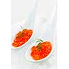Closeup of caviar with dill garnish in two white spoons on ice