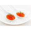 Closeup of caviar with dill garnish in two white spoons on ice