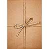 Gift package wrapped in brown paper tied with twine closeup