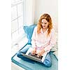 Caucasian woman using laptop computer sitting on couch at home