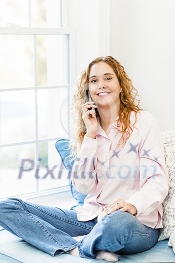 Smiling caucasian woman talking on cordless telephone at home Smiling caucasian woman talking on cordless telephone at home