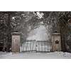 Spooky old broken gate on driveway in winter