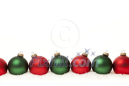 Row of green and red Christmas ornaments on white background Row of green and red Christmas ornaments on white background