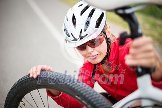 Pretty, young female biker outdoors on her mountain bike (shallow DOF; selective focus)